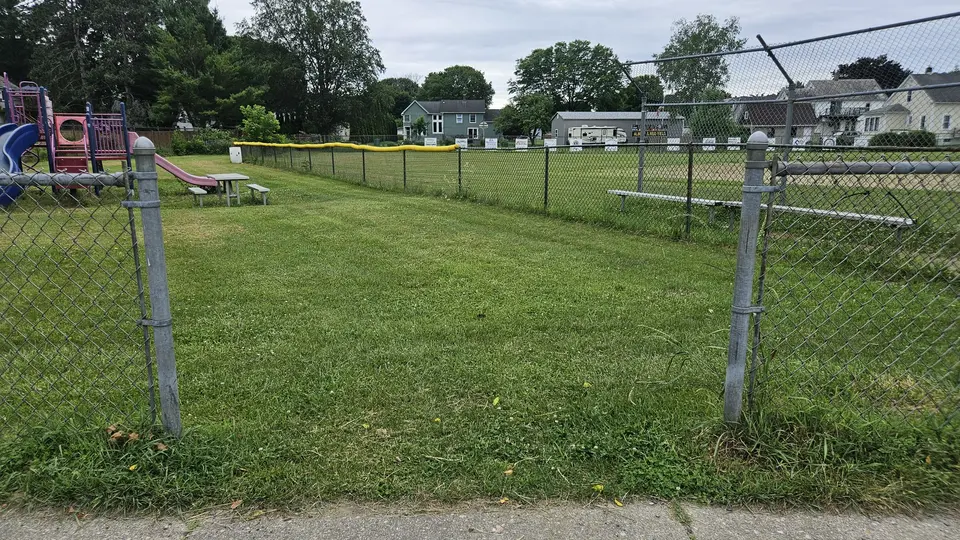 A large gap in the fence to enter the playground area.