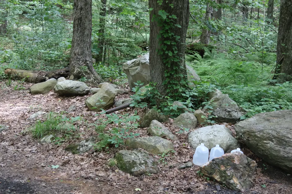 A small designated area holds water jugs for thru hikers on the northbound side of the trail intersection.