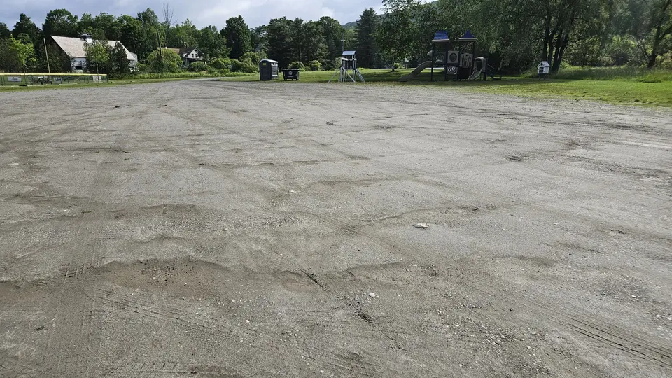 The parking lot, made of dirt and stone, smoothed, but occasionally muddied