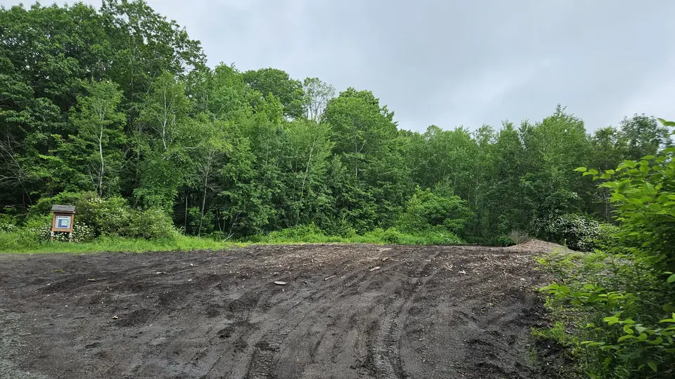 The parking area, comprised of dirt. Currently uneven