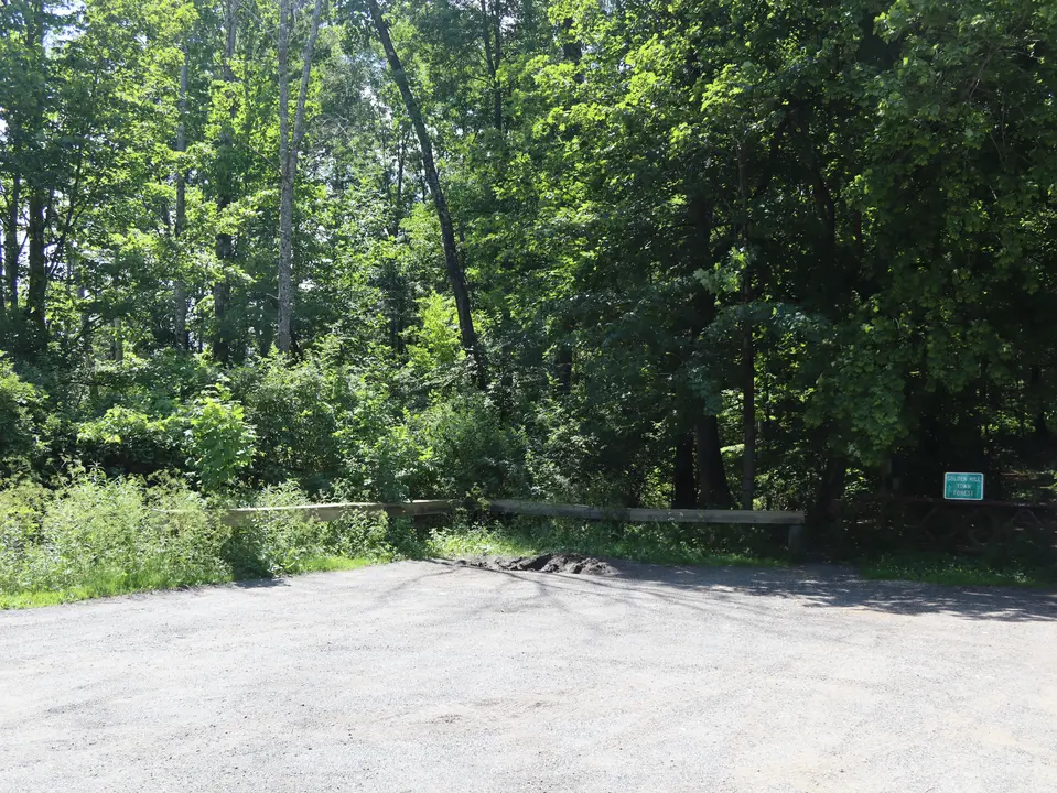 Compact, gravel parking area for Golden Hill Forest. A small section in the corner of the lot is uneven.