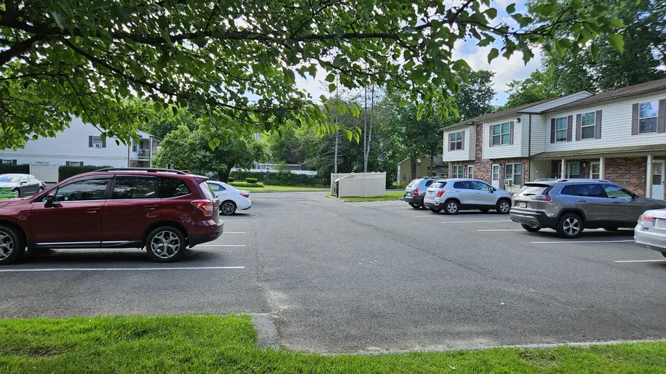 The parking area by the apartment complex, as well as the entrance to the park.