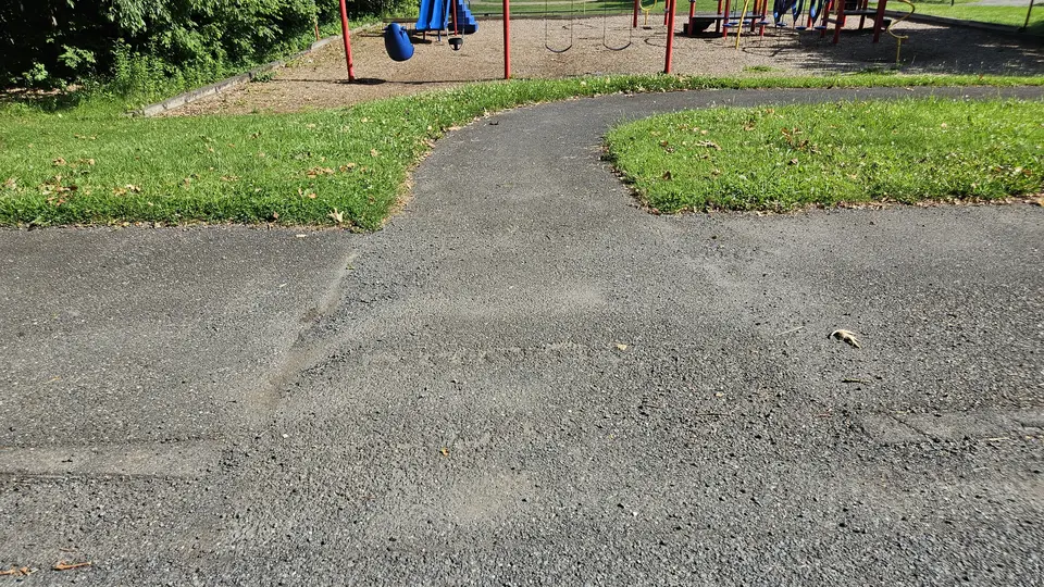 A portion of the paved path, that connects the parking lot to the playground.