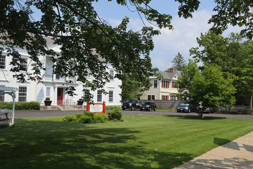 Cars line a small parking area in the front of the Lenox Community Center Building, which is off of Walker Street.