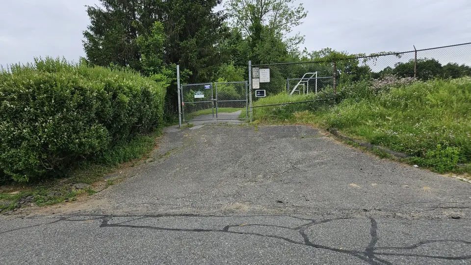 The steep, uneven, paved slope into the park entrance.