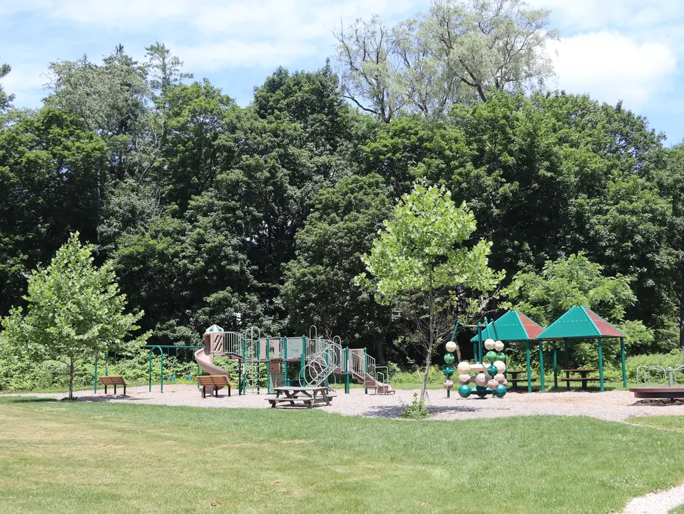 Tillotson Park. A narrow gravel path (to the right) provides access to the park from the parking area.
