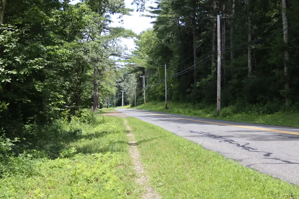 A short dirt path runs alongside Tyringham Road, connecting the parking area to the trail.