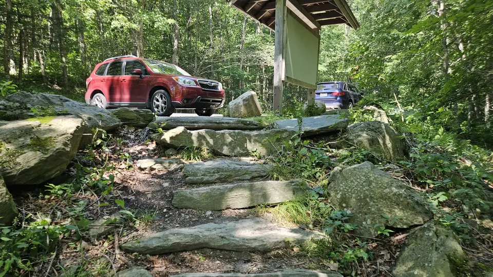 Large, 10 inch high, stone steps leading from the parking lot down to the trailhead.