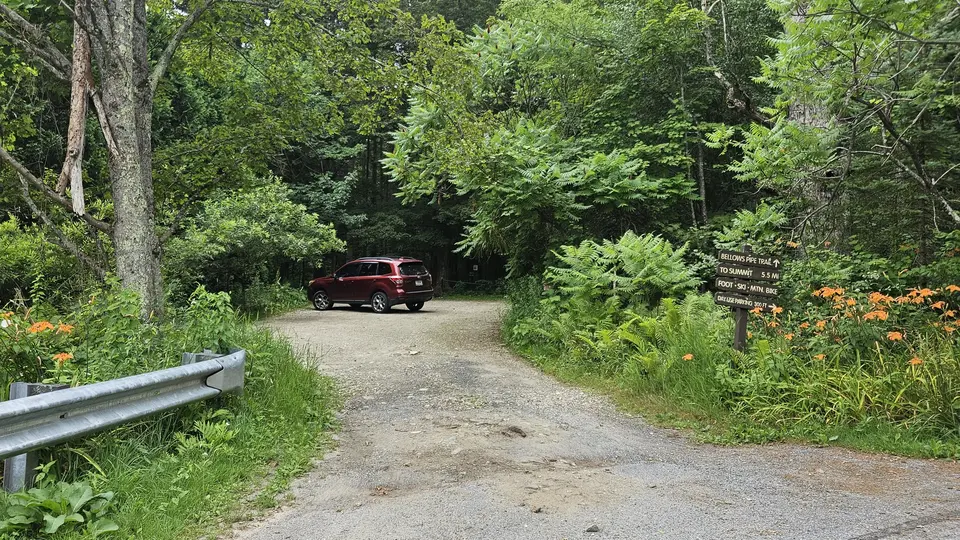 The gravel parking lot and trailhead sign.