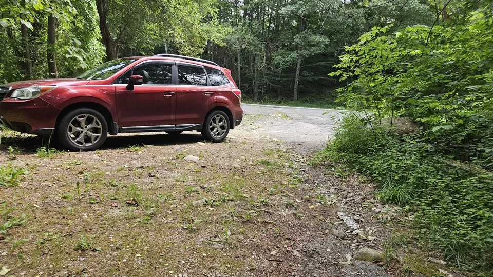 The small, uneven, and unpaved parking area.