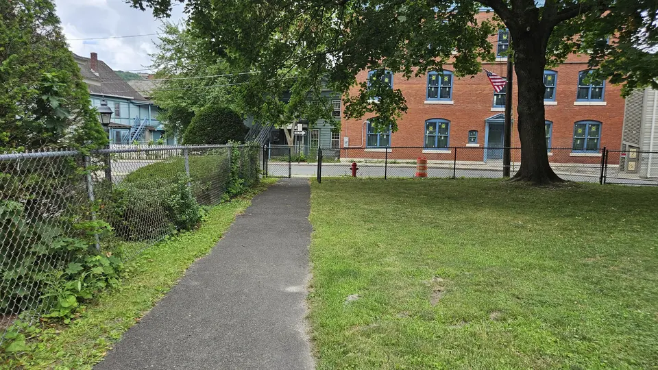 A paved path running from the entrance gate to the upper section of the park.
