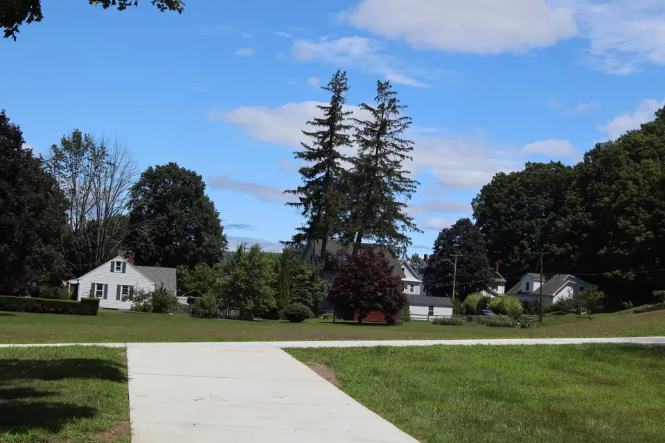 Sidewalk access runs alongside Dewey Park from the parking area.