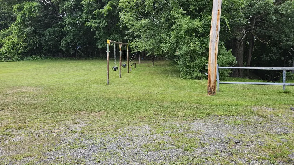 The flat grass that leads down to the swings.