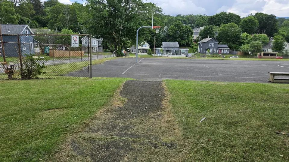 The paved path that runs to the basketball court from the parking lot.