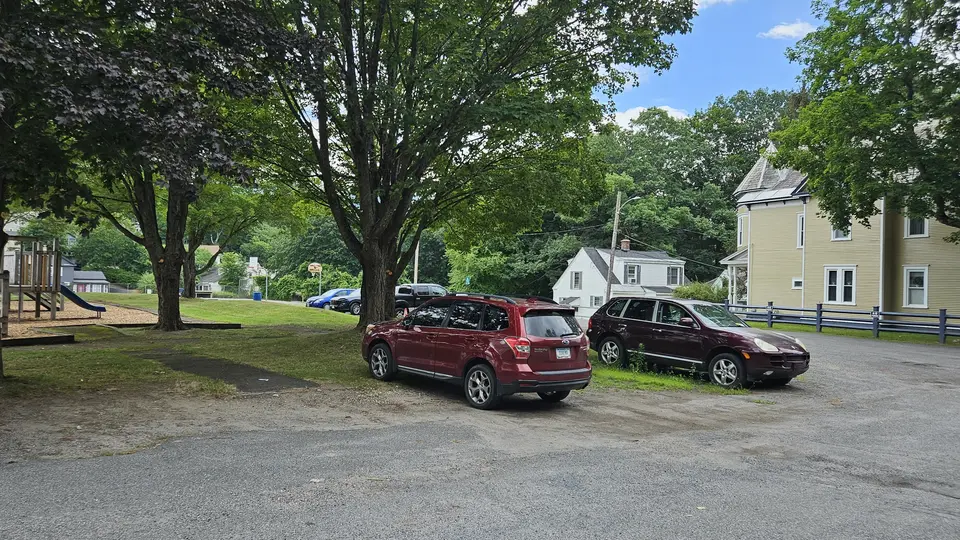 The area for parking in the grass by the paved road.