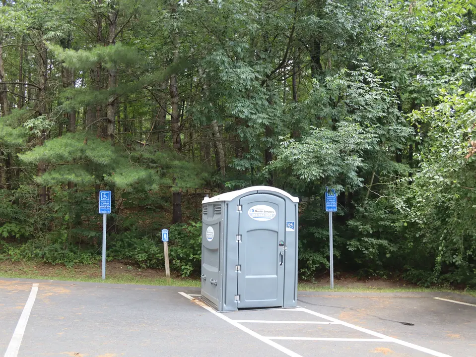 An accessible restroom in the Lake Buel Boat Launch parking area, alongside 2 accessible parking spaces.
