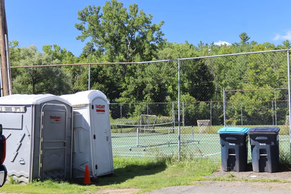 Two portable restrooms sit adjacent to the park entrance.