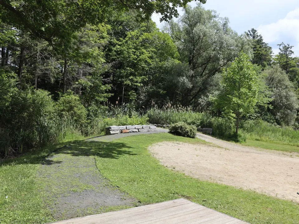 A flat, accessible gravel path connects the accessible parking area to Lenox Town Beach area, such as the sandy beach and restroom building.