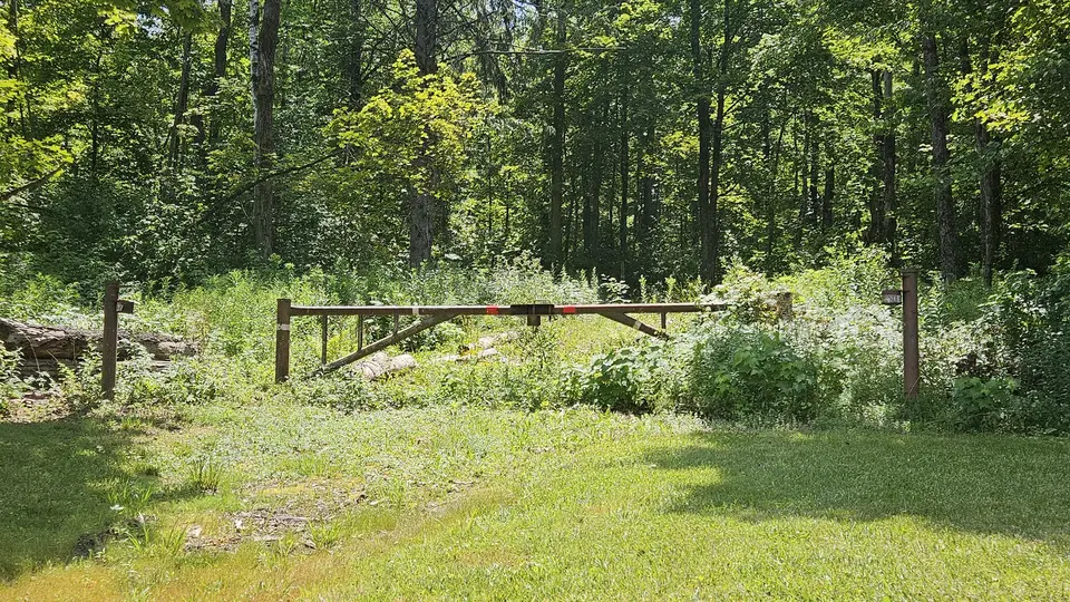The trailhead, at the top of a steep grass hill.