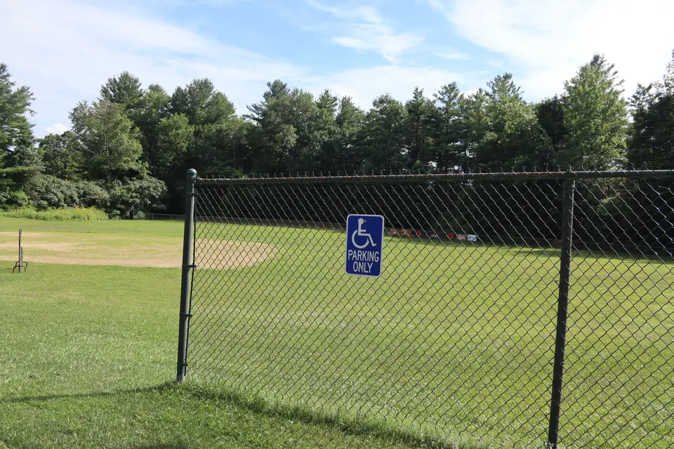An accessible parking space located adjacent to the baseball field.