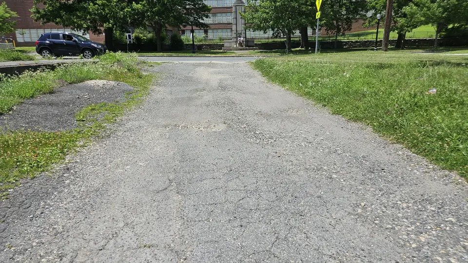 The driveway that leads to the parking area.