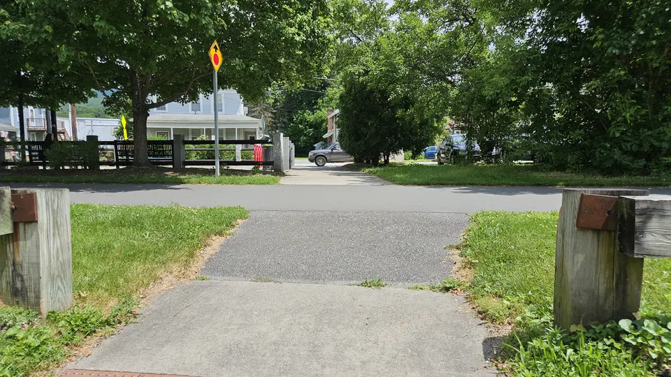 The sidewalk that leads into the park.