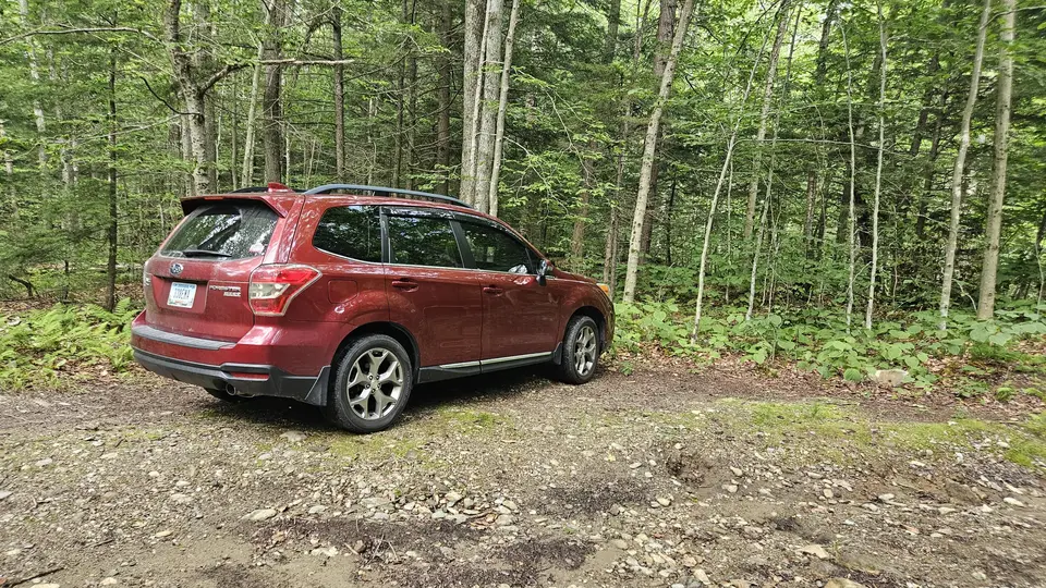 A small dirt parking area for two cars.
