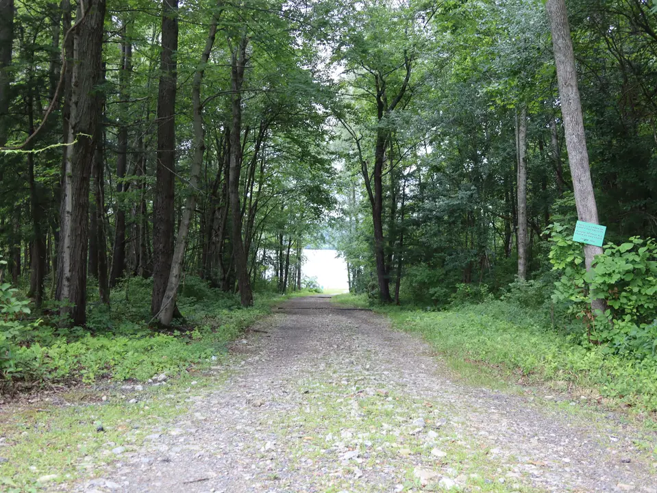 A gravel road connects the main parking area to the beach.
