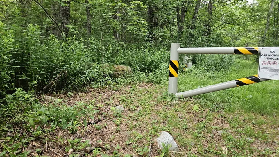 The trailhead with a fence, and a 3-foot wide gap on one side.