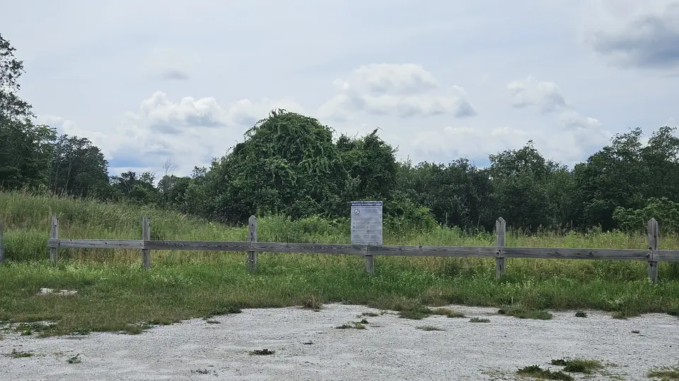 A sign and fence by the parking lot, indicating the presence of local wildlife.