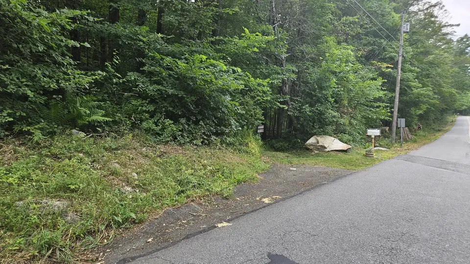 The small pull off area for parking, on uneven grass and gravel.