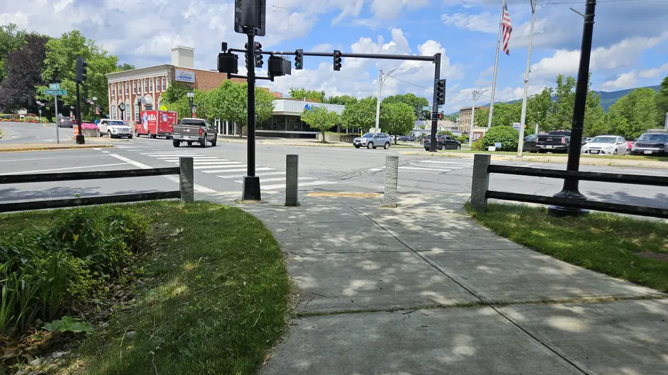 The sidewalk entrance by the road crossing.
