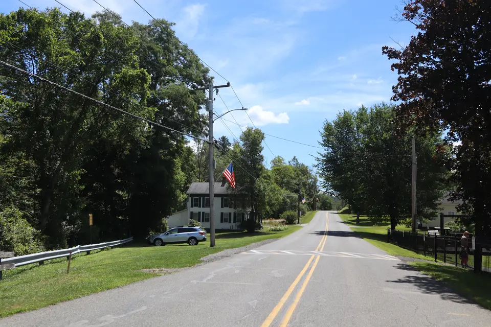 Entrance to Tyringham Town Park (right) from Tyringham Road, facing southwest. Parking area can be seen on the grass to the left. 
