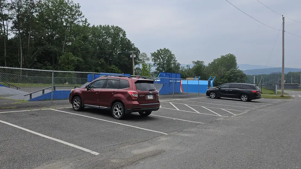 The paved parking area by the skate park.