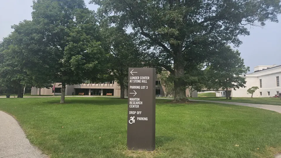 A sign indicating the handicap drop off zone and designated handicap parking lot.