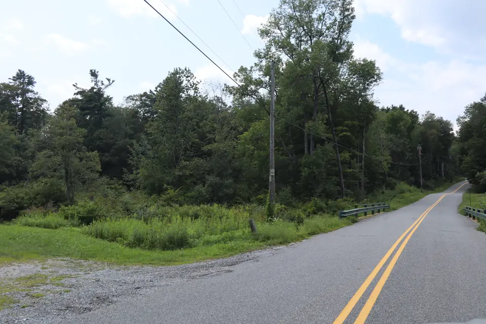 Entrance to the Farmington River Boat Launch parking area (left) off Ed Jones Road, facing west.