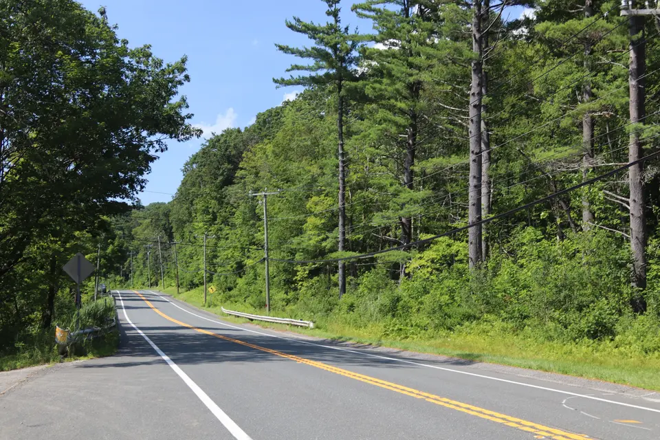 Entrance to the Greenwater Pond Boat Ramp (left) off Route 20, facing West.