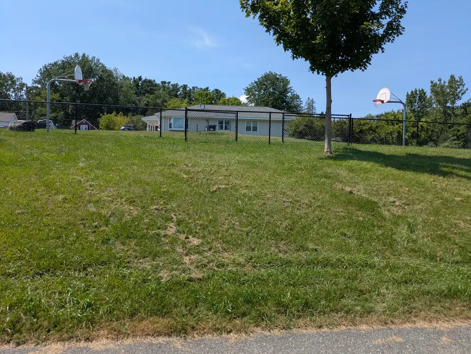 Grass embankment up to the basketball courts